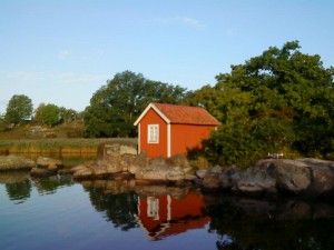 En röd liten stuga på Tjärö i tidigt morgonljus